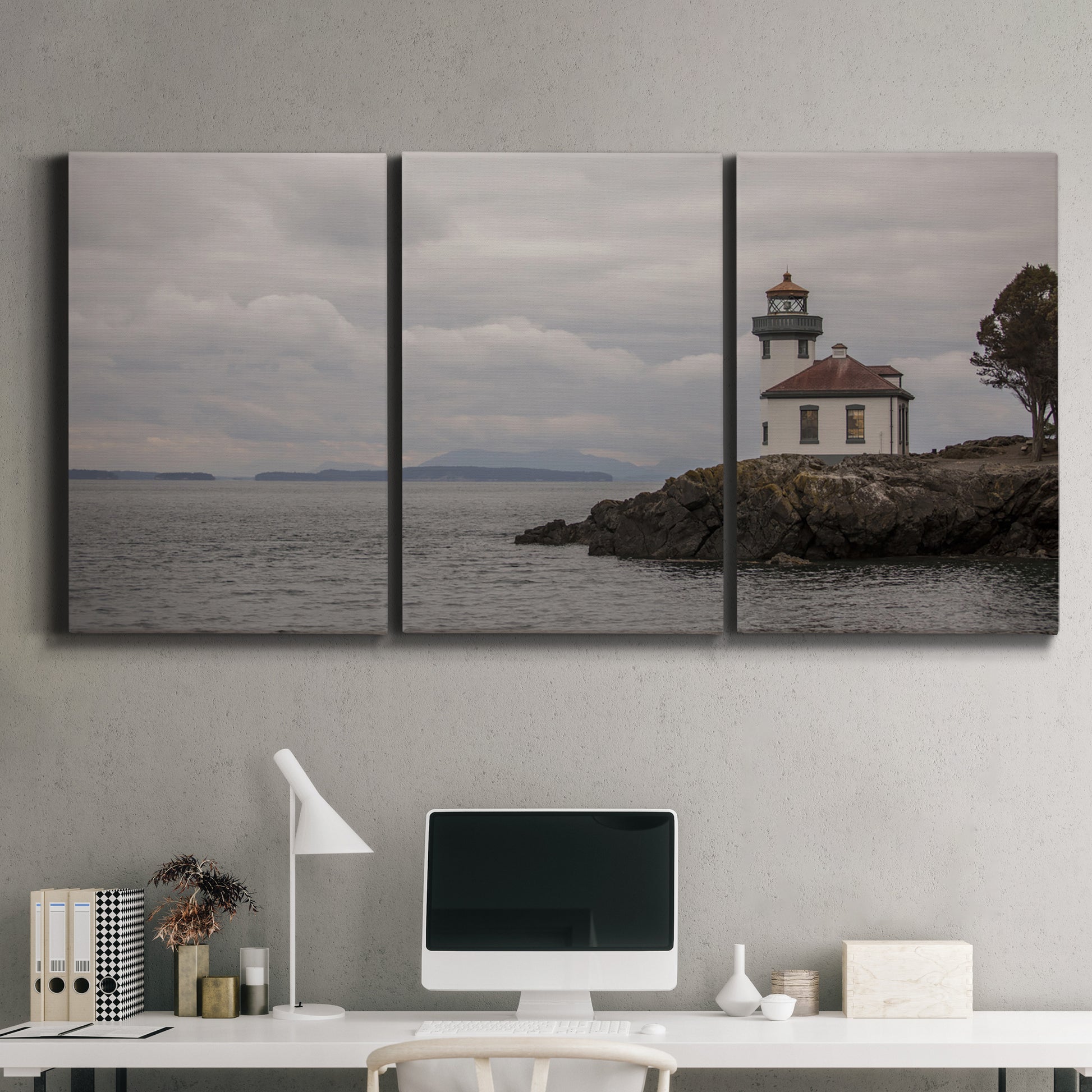Three-panel canvas wall art featuring lighthouse watching over coastline, displayed above a desk in a home office.