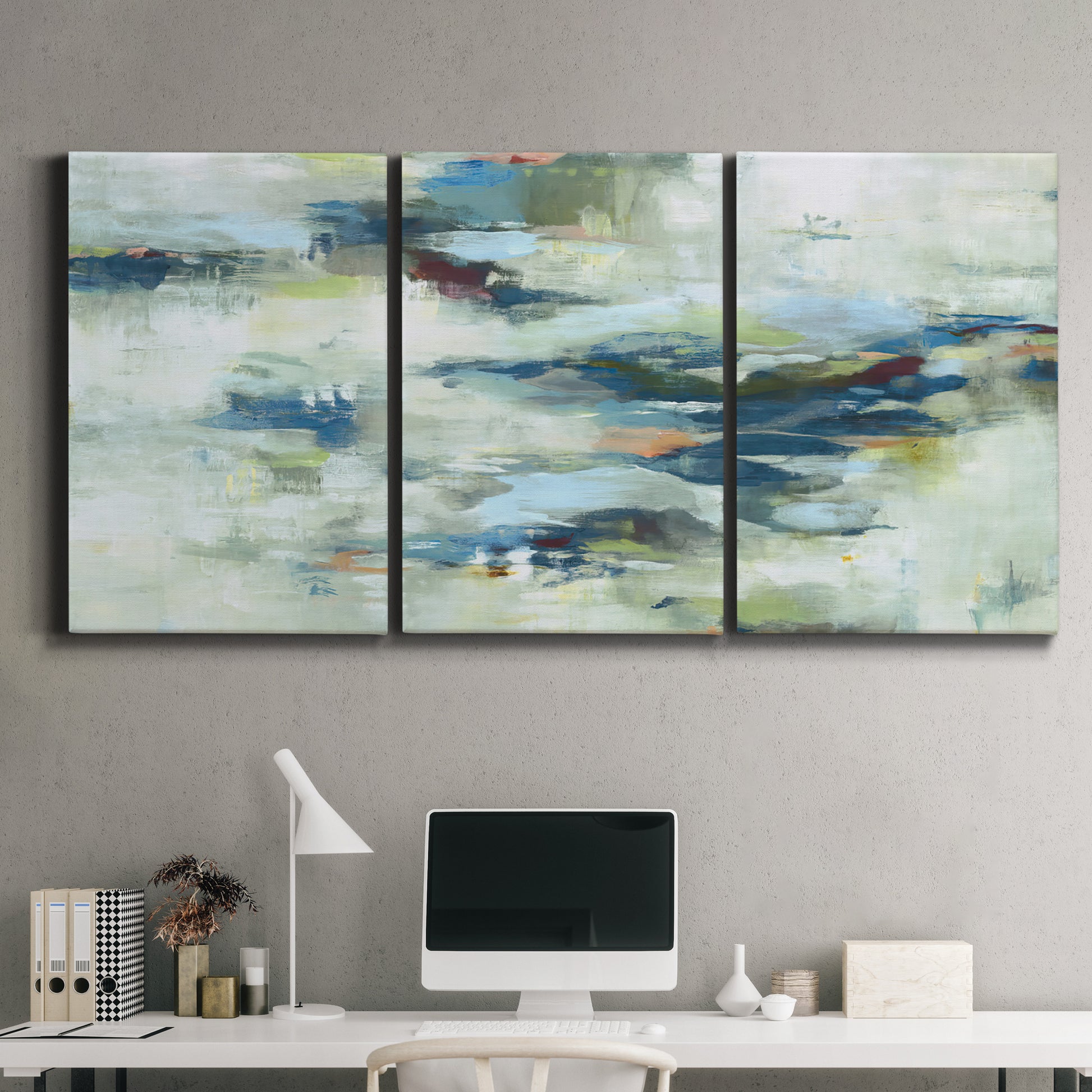 Three-panel canvas wall art featuring dreamlike abstract drifting motion, displayed above a desk in a home office.