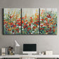 Three-panel canvas wall art featuring colorful garden flowers in bloom, displayed above a desk in a home office.