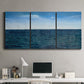 Three-panel canvas wall art featuring open water landscape with wide horizon, displayed above a desk in a home office.