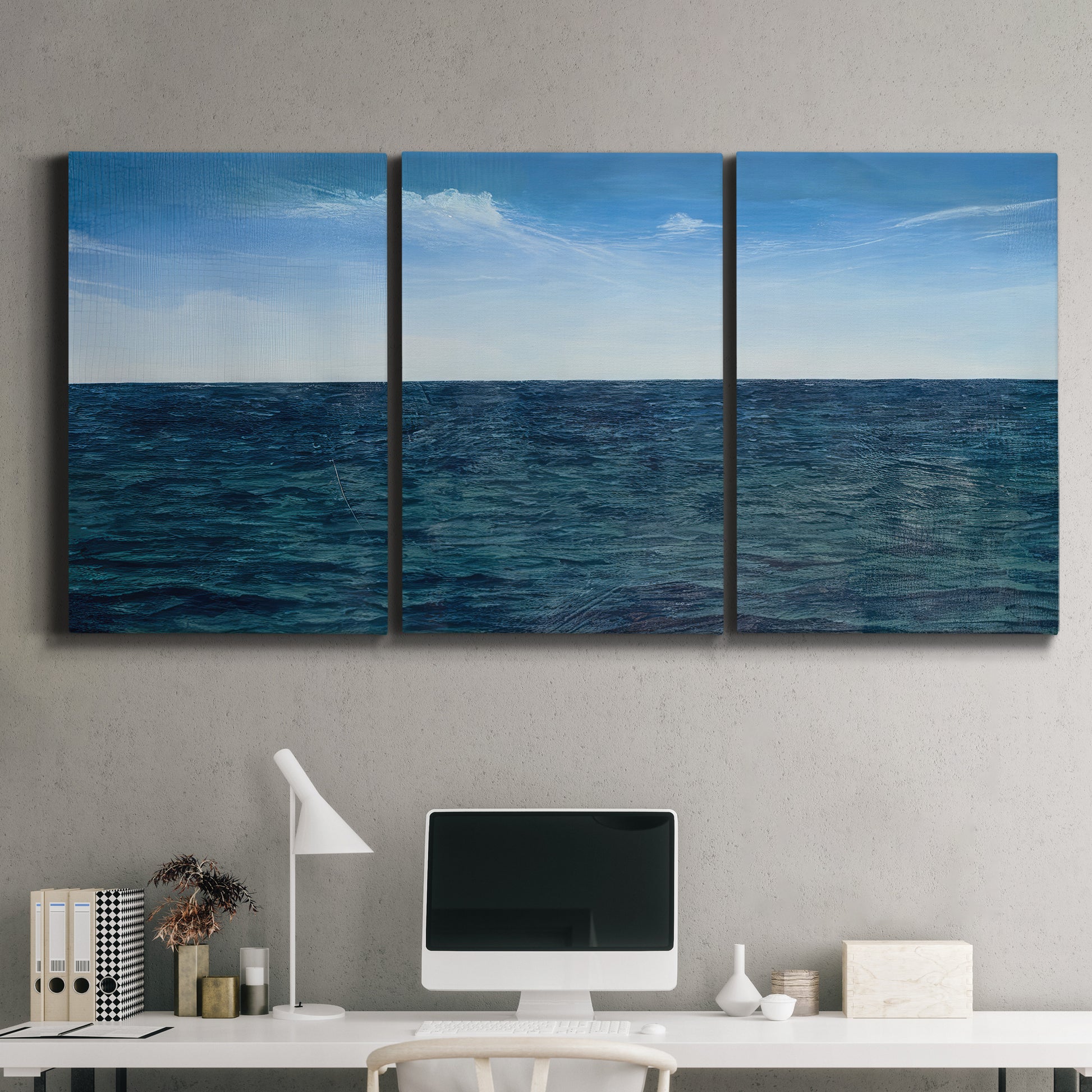 Three-panel canvas wall art featuring open water landscape with wide horizon, displayed above a desk in a home office.