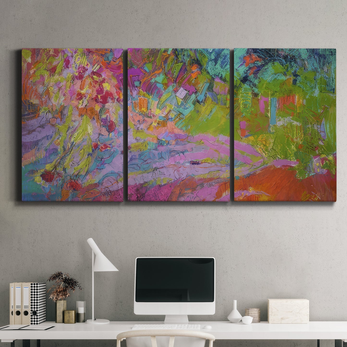 Three-panel canvas wall art featuring vibrant abstract with dramatic motion, displayed above a desk in a home office.