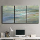 Three-panel canvas wall art featuring soft coastal beach light landscape, displayed above a desk in a home office.