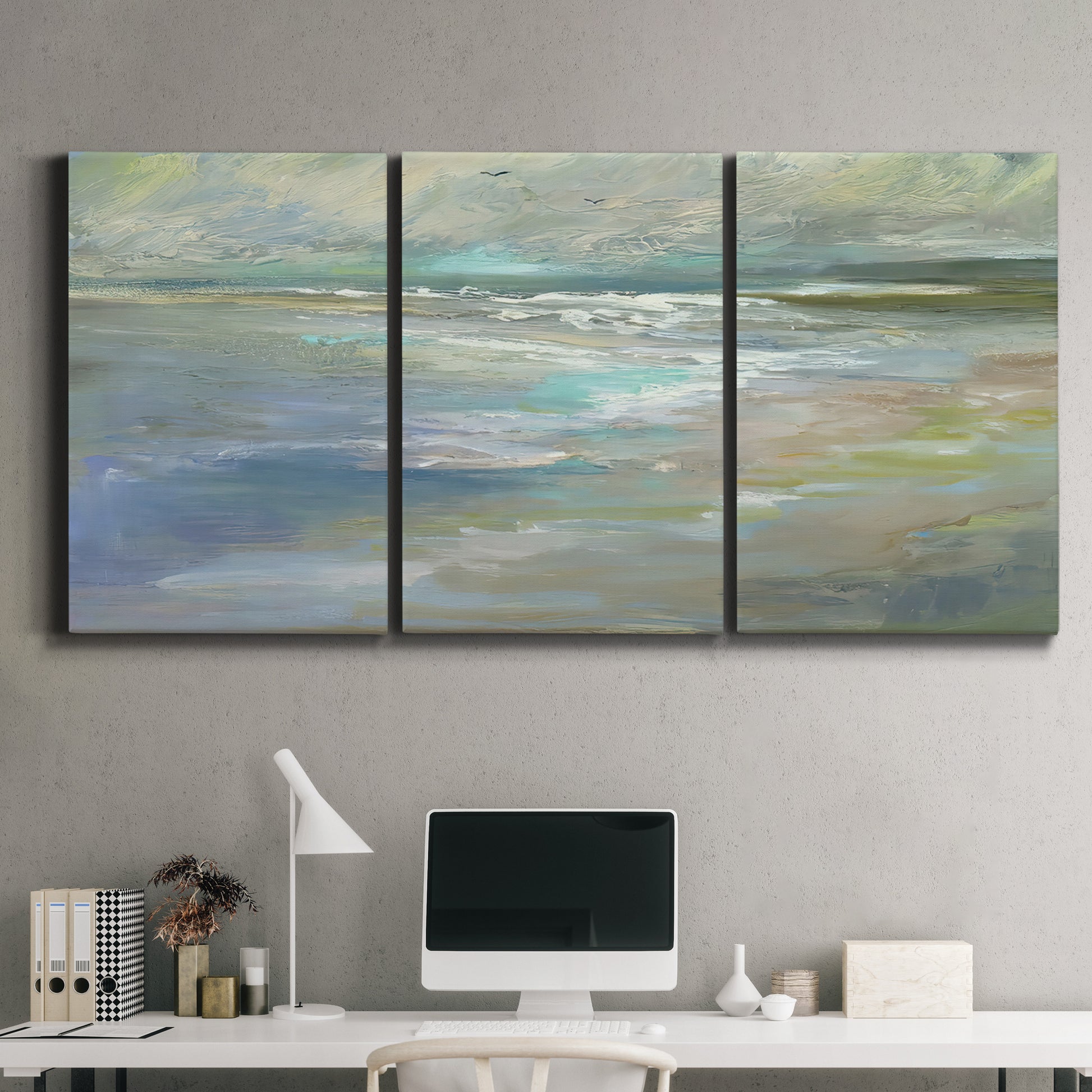 Three-panel canvas wall art featuring soft coastal beach light landscape, displayed above a desk in a home office.