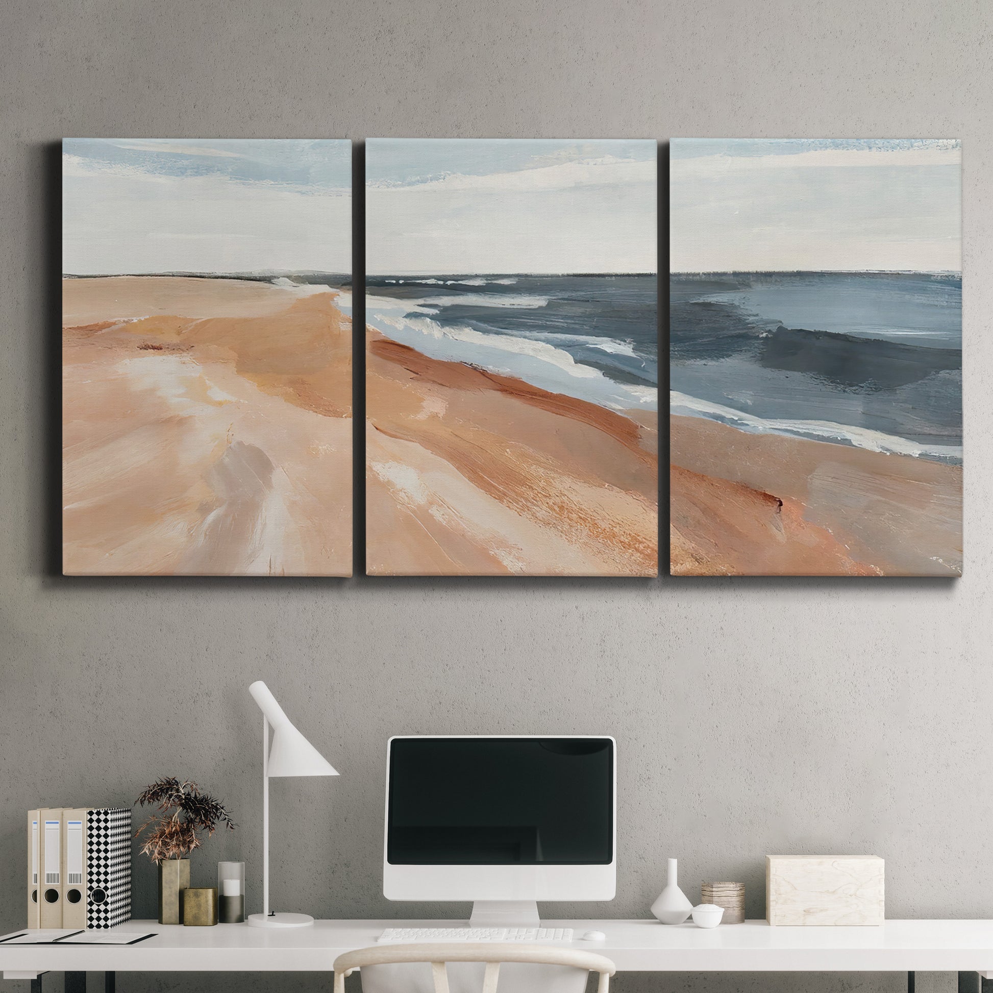 Three-panel canvas wall art featuring abstract coastal beach composition, displayed above a desk in a home office.