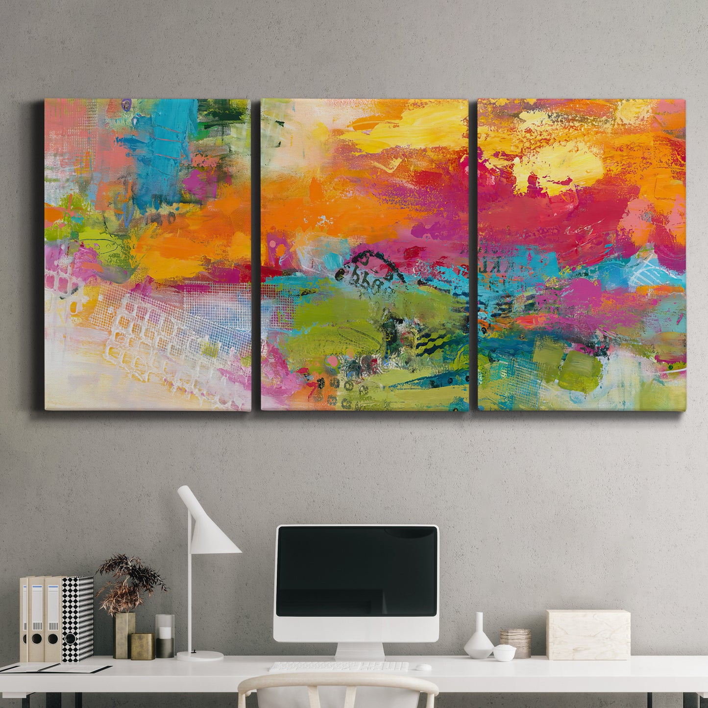 Three-panel canvas wall art featuring expressive abstract sunset tones, displayed above a desk in a home office.