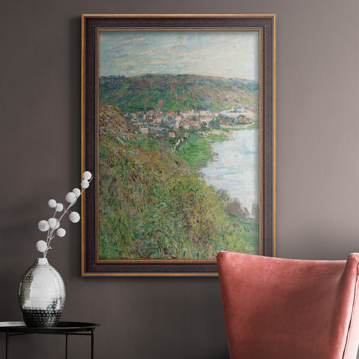 Impressionist landscape view of Vétheuil by Claude Monet in an ornate bronzed mahogany wood frame displayed in a neutral interior setting.