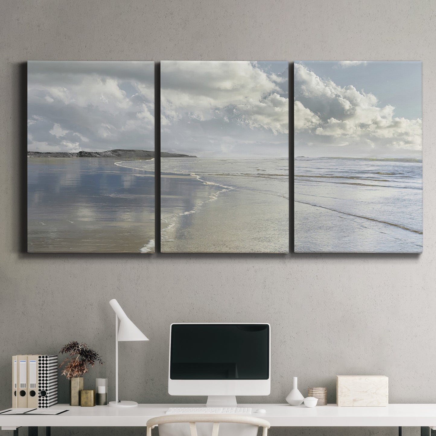 Three-panel canvas wall art featuring endless beach meeting ocean horizon, displayed above a desk in a home office.