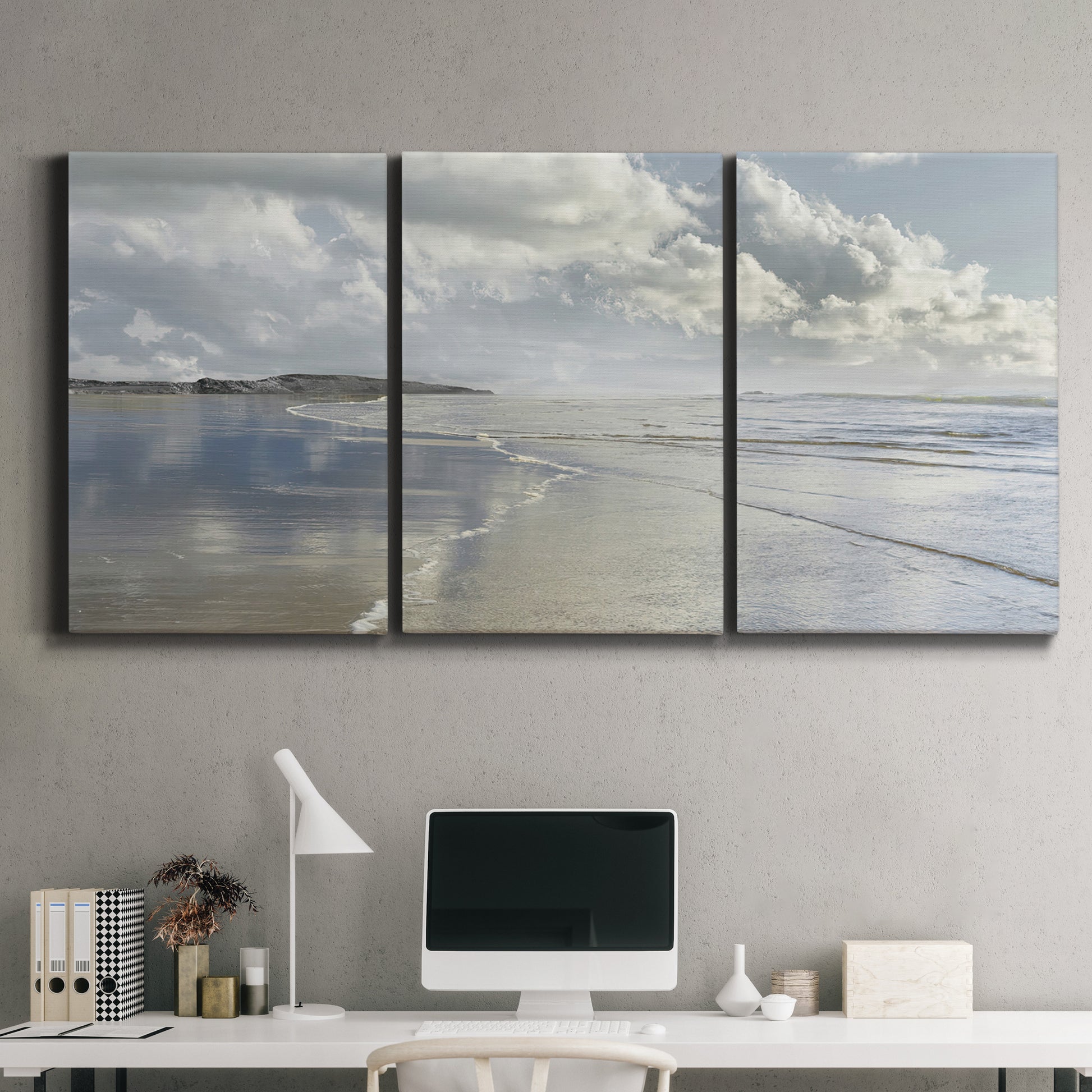 Three-panel canvas wall art featuring endless beach meeting ocean horizon, displayed above a desk in a home office.