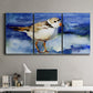 Three-panel canvas wall art featuring shorebirds standing in shallow water, displayed above a desk in a home office.
