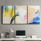 Three-panel canvas wall art featuring bright abstract candy colored strokes, displayed above a desk in a home office.