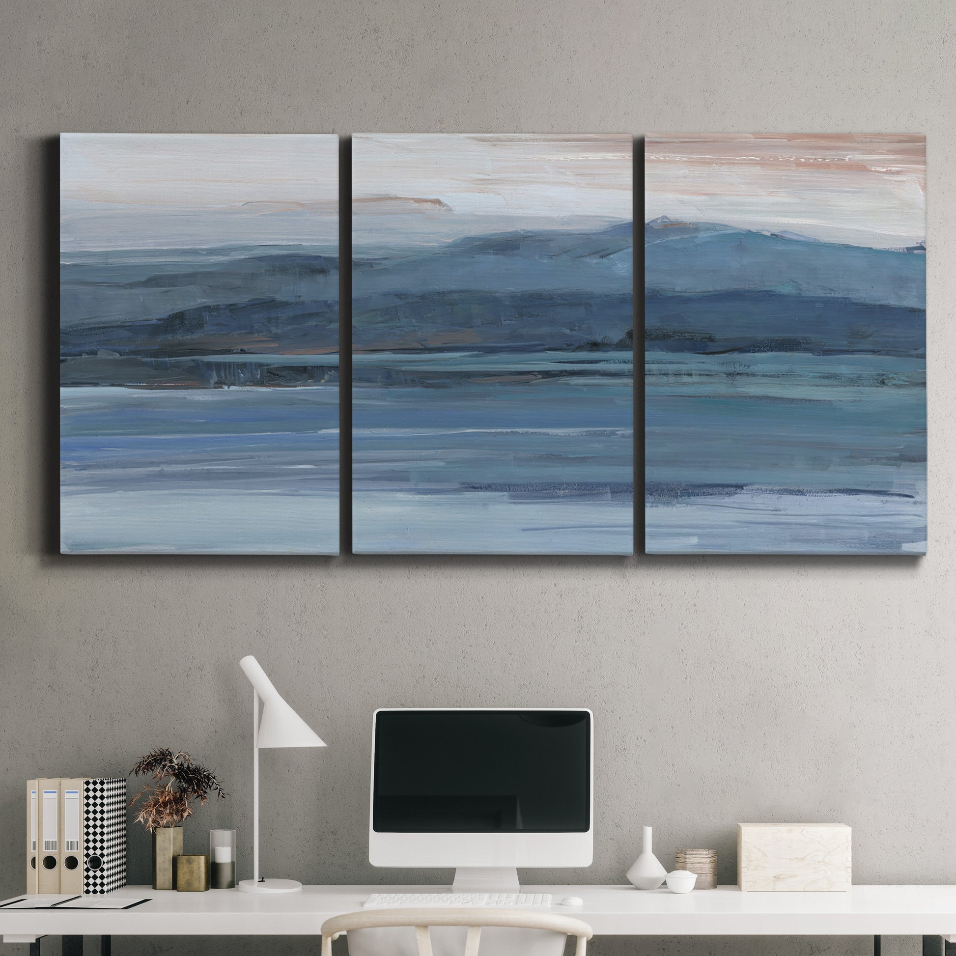 Three-panel canvas wall art featuring wide lake with distant shoreline, displayed above a desk in a home office.