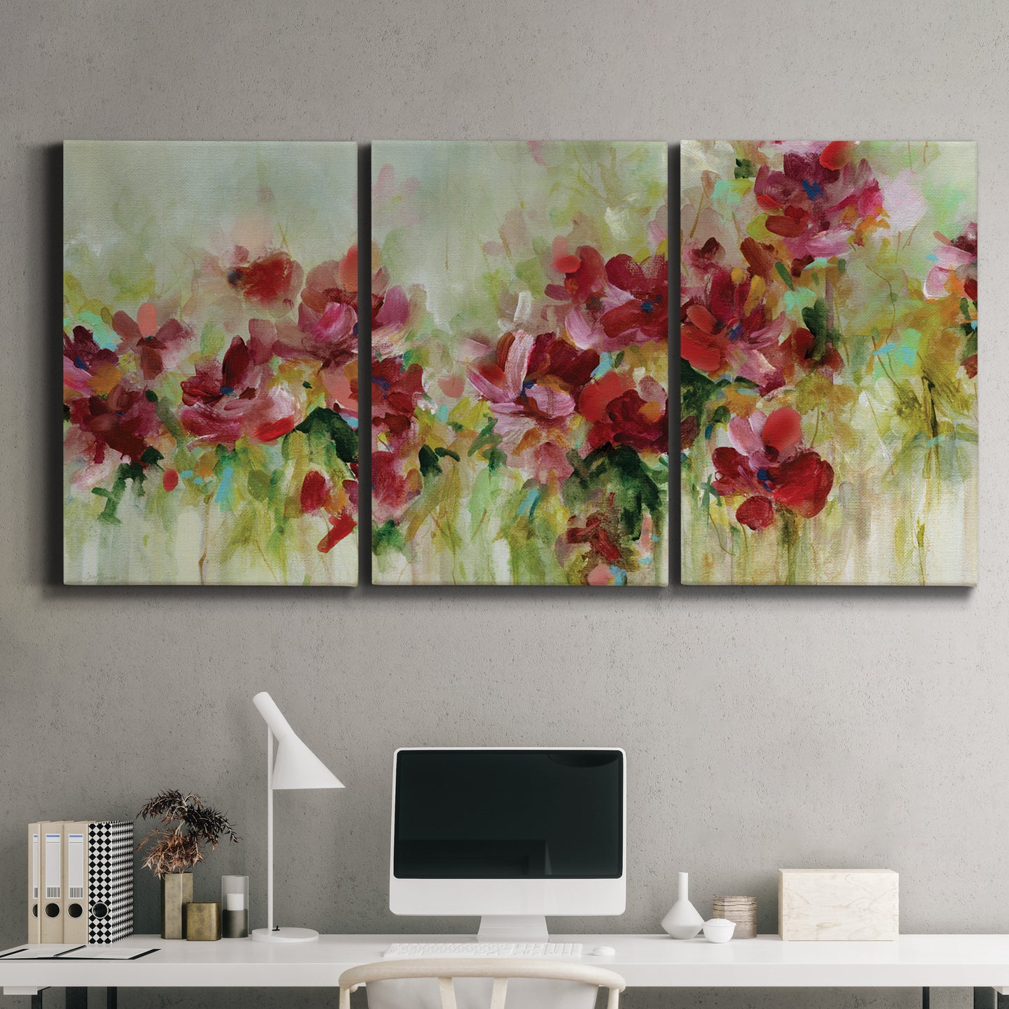 Three-panel canvas wall art featuring colorful floral garden composition, displayed above a desk in a home office.