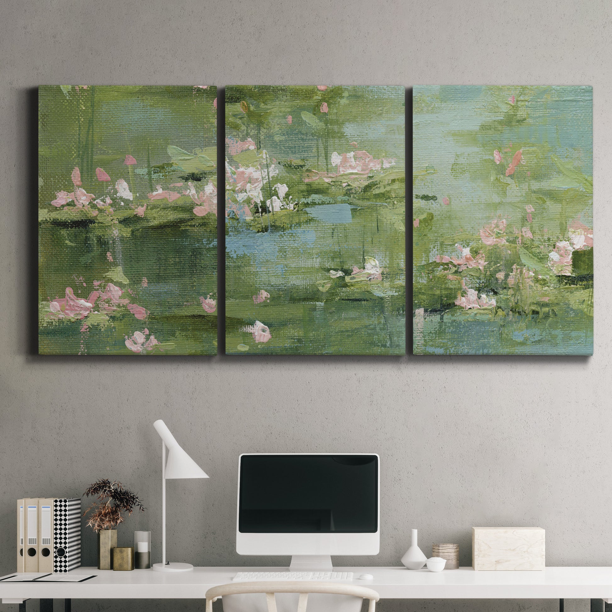 Three-panel canvas wall art featuring soft green water lilies, displayed above a desk in a home office.
