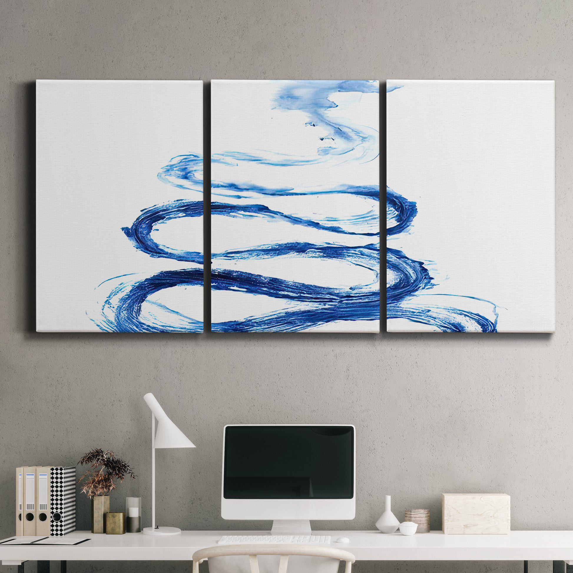 Three-panel canvas wall art featuring indigo abstract vapor watercolor, displayed above a desk in a home office.