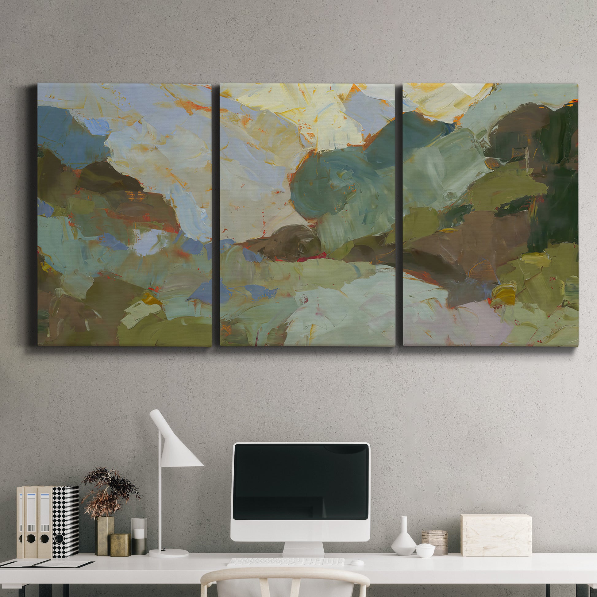 Three-panel canvas wall art featuring abstract landscape suggesting travel pause, displayed above a desk in a home office.