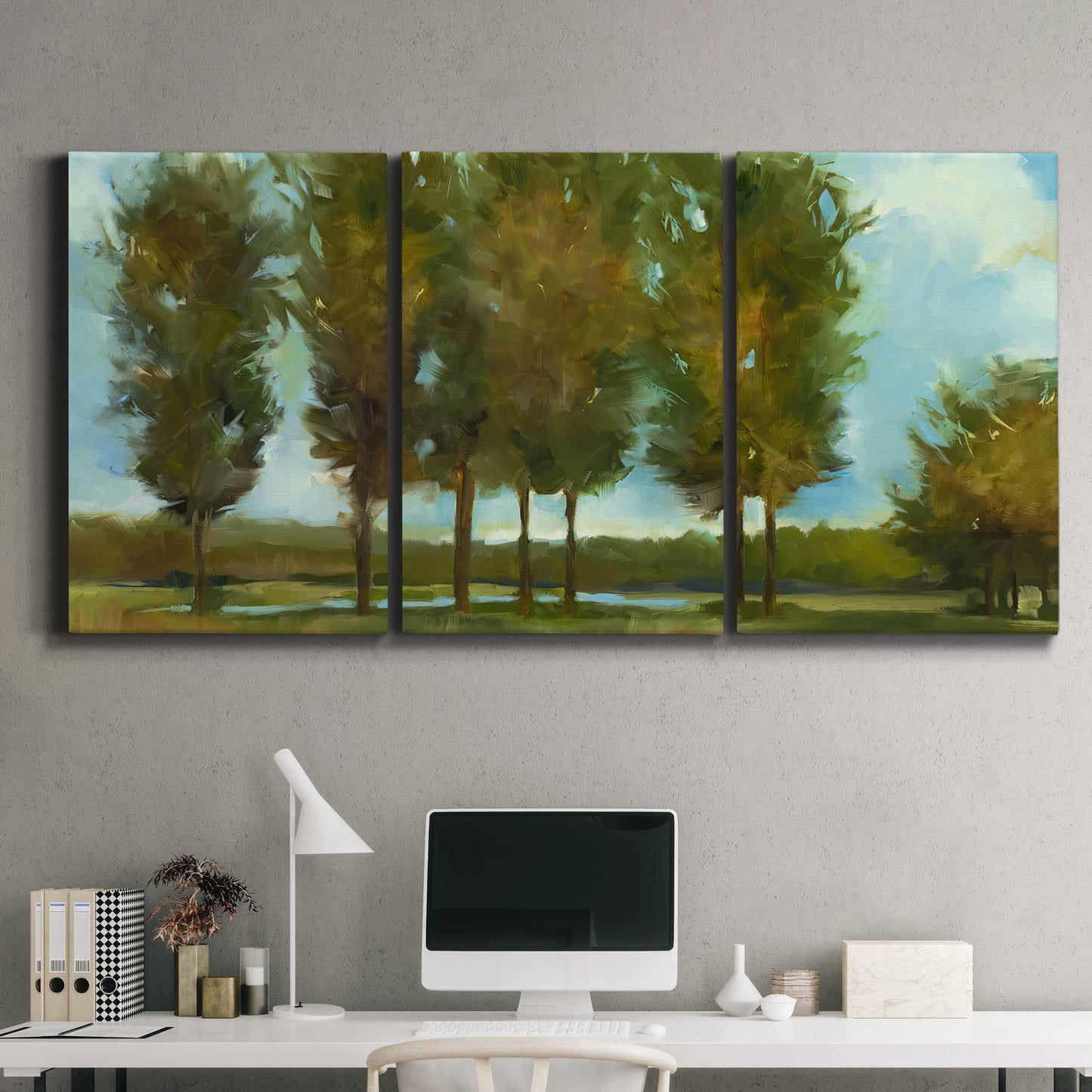 Three-panel canvas wall art featuring tall trees lining open landscape, displayed above a desk in a home office.