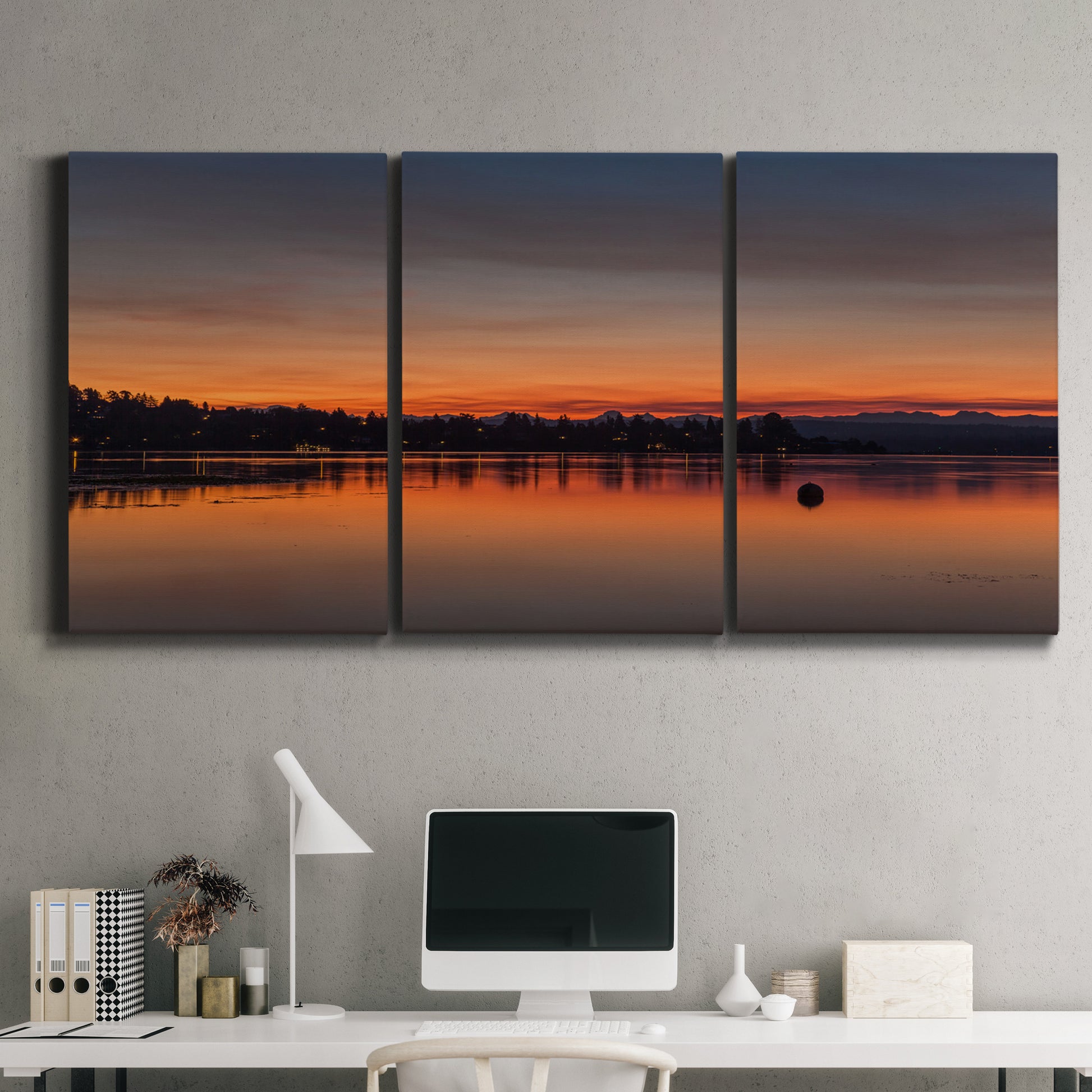 Three-panel canvas wall art featuring glowing sunset over water, displayed above a desk in a home office.