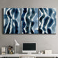 Three-panel canvas wall art featuring flowing blue watercolor wave forms, displayed above a desk in a home office.