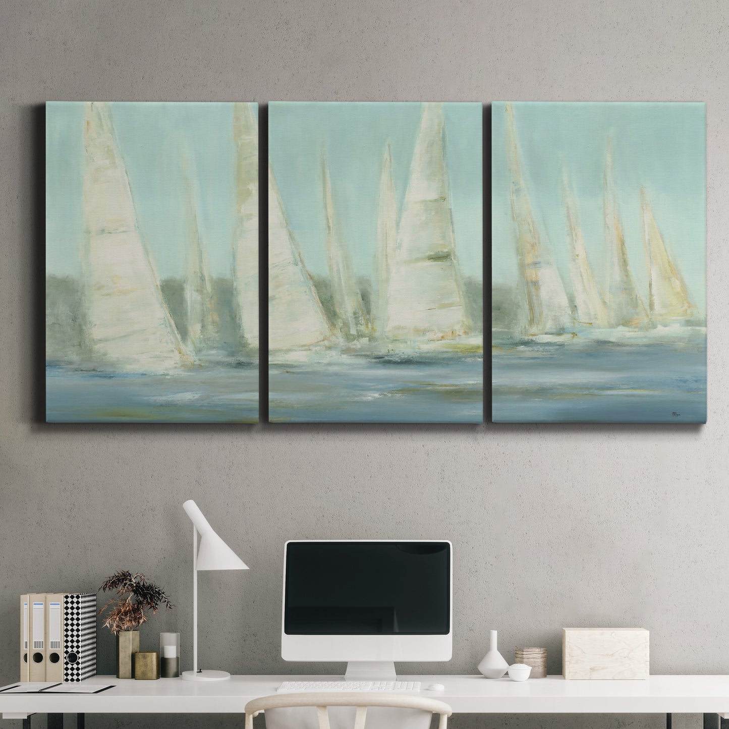 Three-panel canvas wall art featuring sailboats silhouetted at sunrise, displayed above a desk in a home office.
