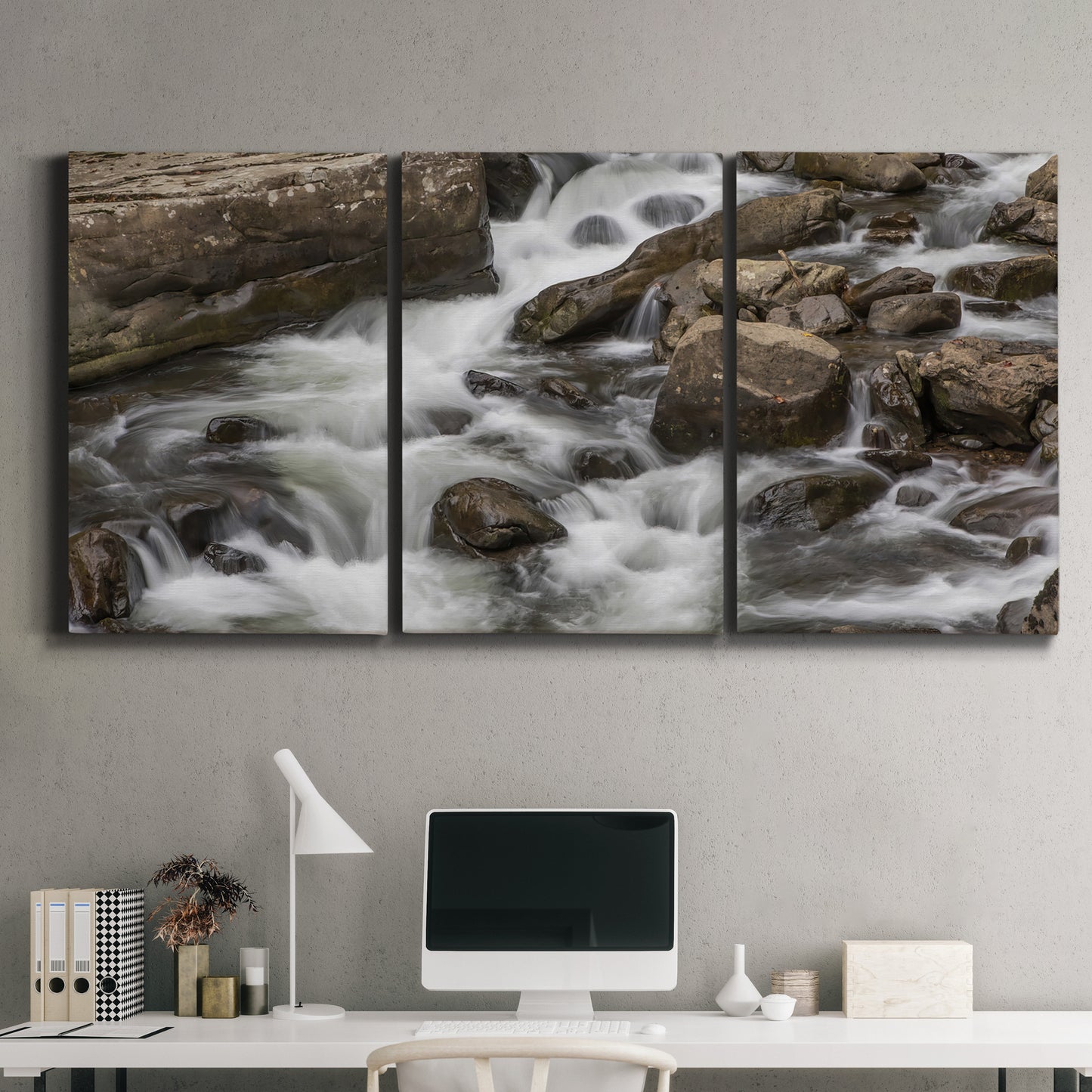 Three-panel canvas wall art featuring rushing river water over rocks, displayed above a desk in a home office.