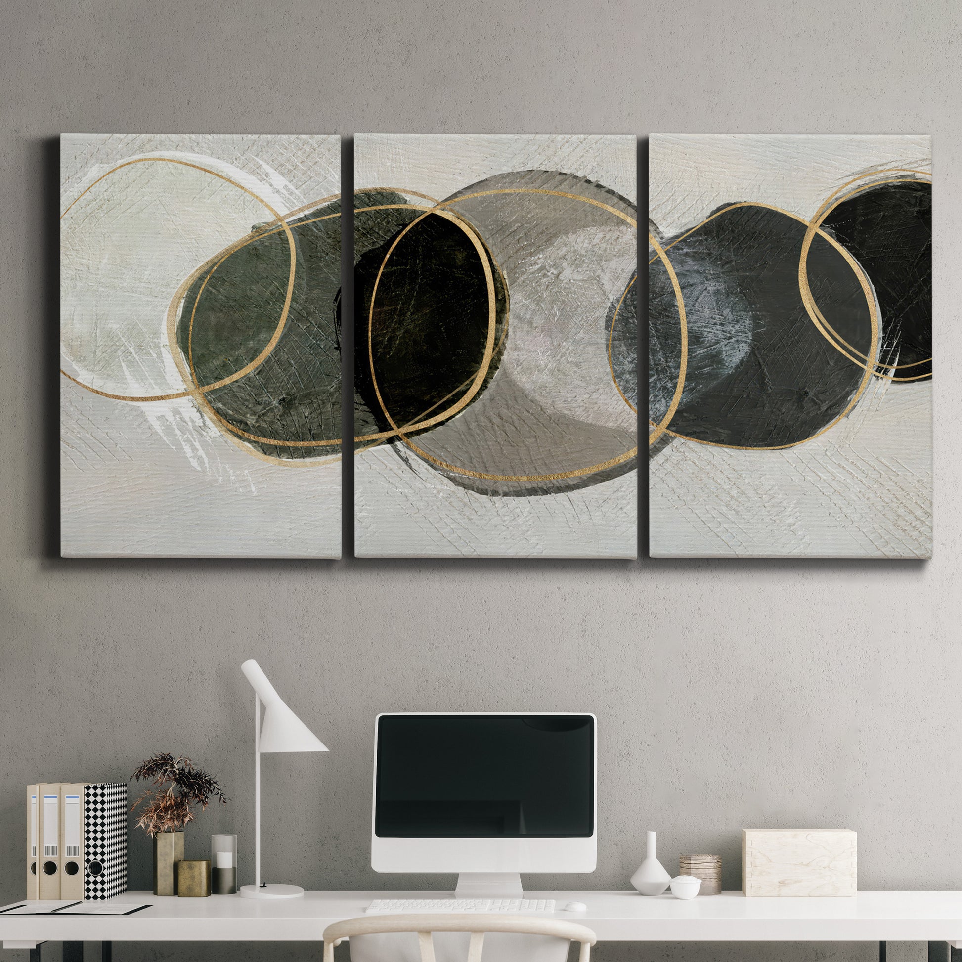 Three-panel canvas wall art featuring smooth abstract river stone forms, displayed above a desk in a home office.
