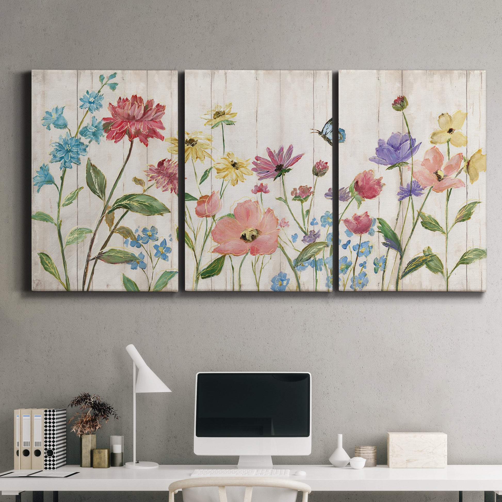 Three-panel canvas wall art featuring delicate wildflower illustration, displayed above a desk in a home office.