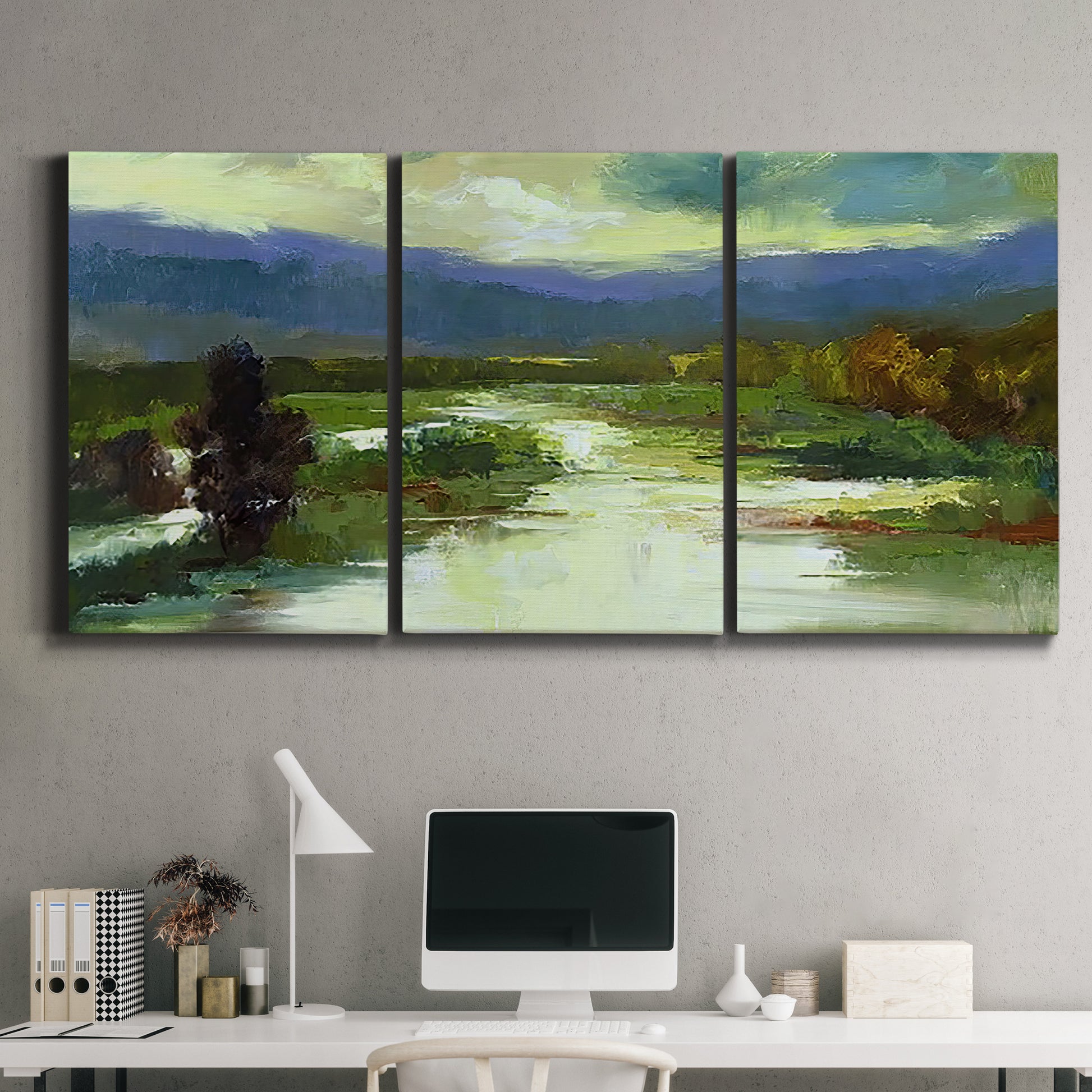 Three-panel canvas wall art featuring open meadow landscape with distant hills, displayed above a desk in a home office.