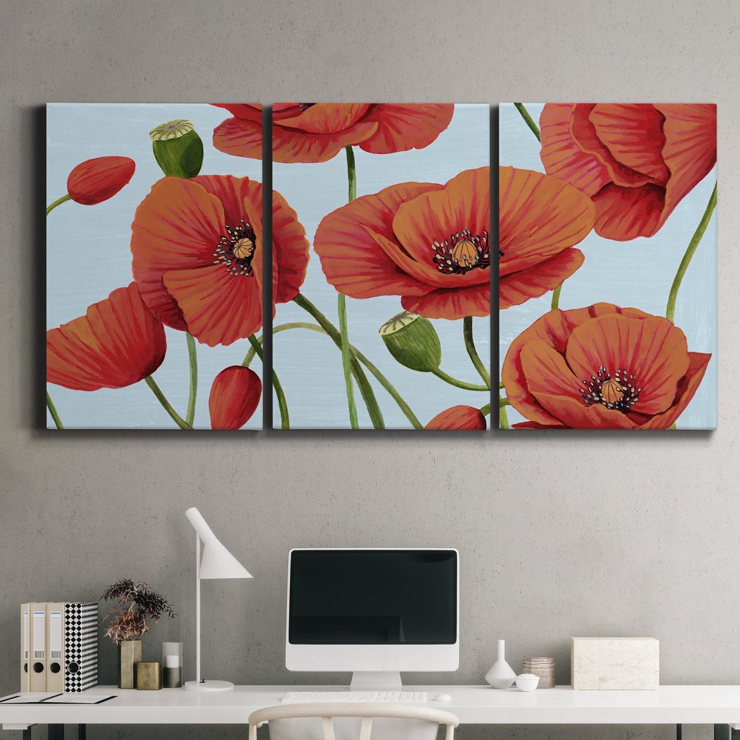 Three-panel canvas wall art featuring red poppies in motion, displayed above a desk in a home office.