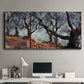 Three-panel canvas wall art featuring pine trees silhouetted at evening, displayed above a desk in a home office.