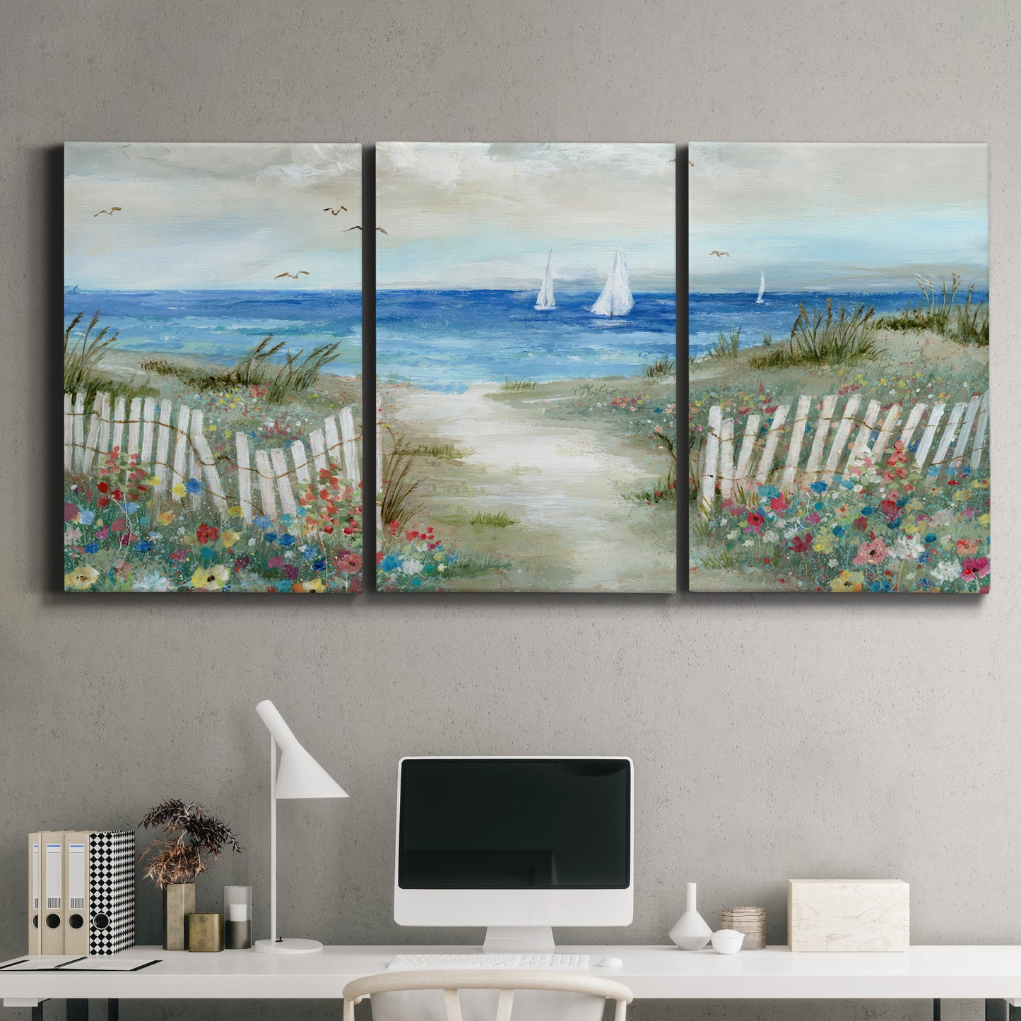 Three-panel canvas wall art featuring lush coastal garden landscape, displayed above a desk in a home office.