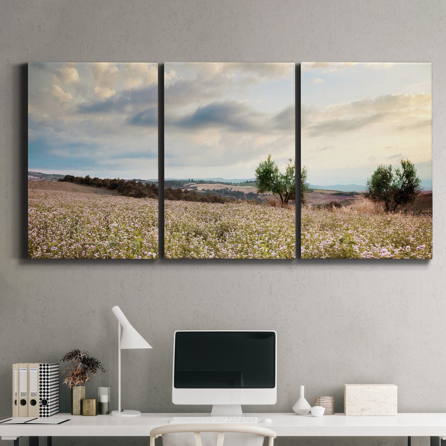 Three-panel canvas wall art featuring wildflowers across tuscan landscape, displayed above a desk in a home office.