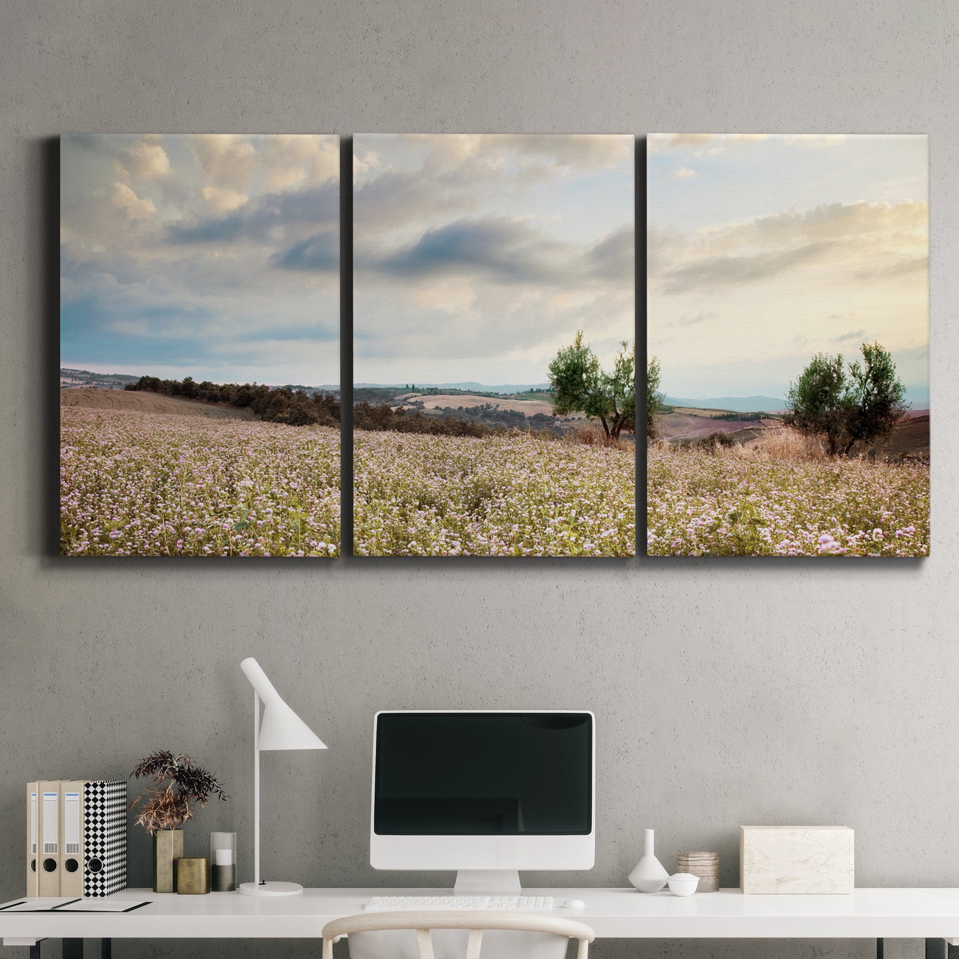 Three-panel canvas wall art featuring wildflowers across tuscan landscape, displayed above a desk in a home office.