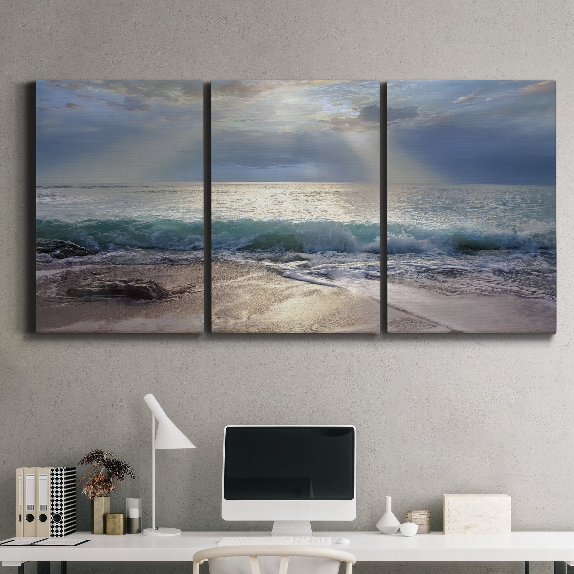 Three-panel canvas wall art featuring soft sunrise over open water, displayed above a desk in a home office.
