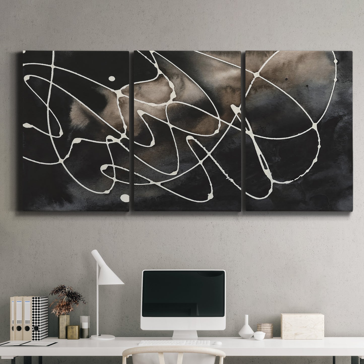 Three-panel canvas wall art featuring dark swirling abstract motion, displayed above a desk in a home office.