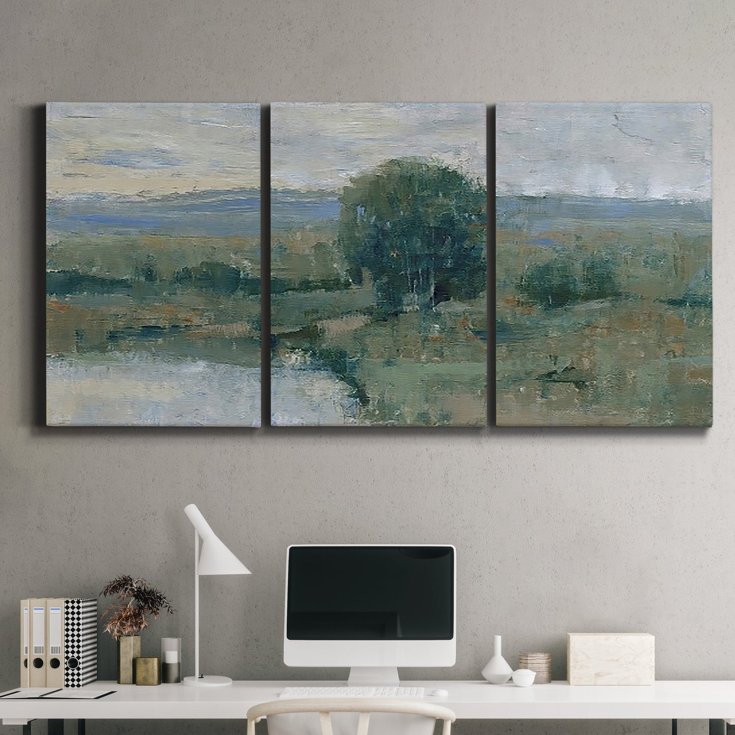 Three-panel canvas wall art featuring riverbank landscape with reflections, displayed above a desk in a home office.