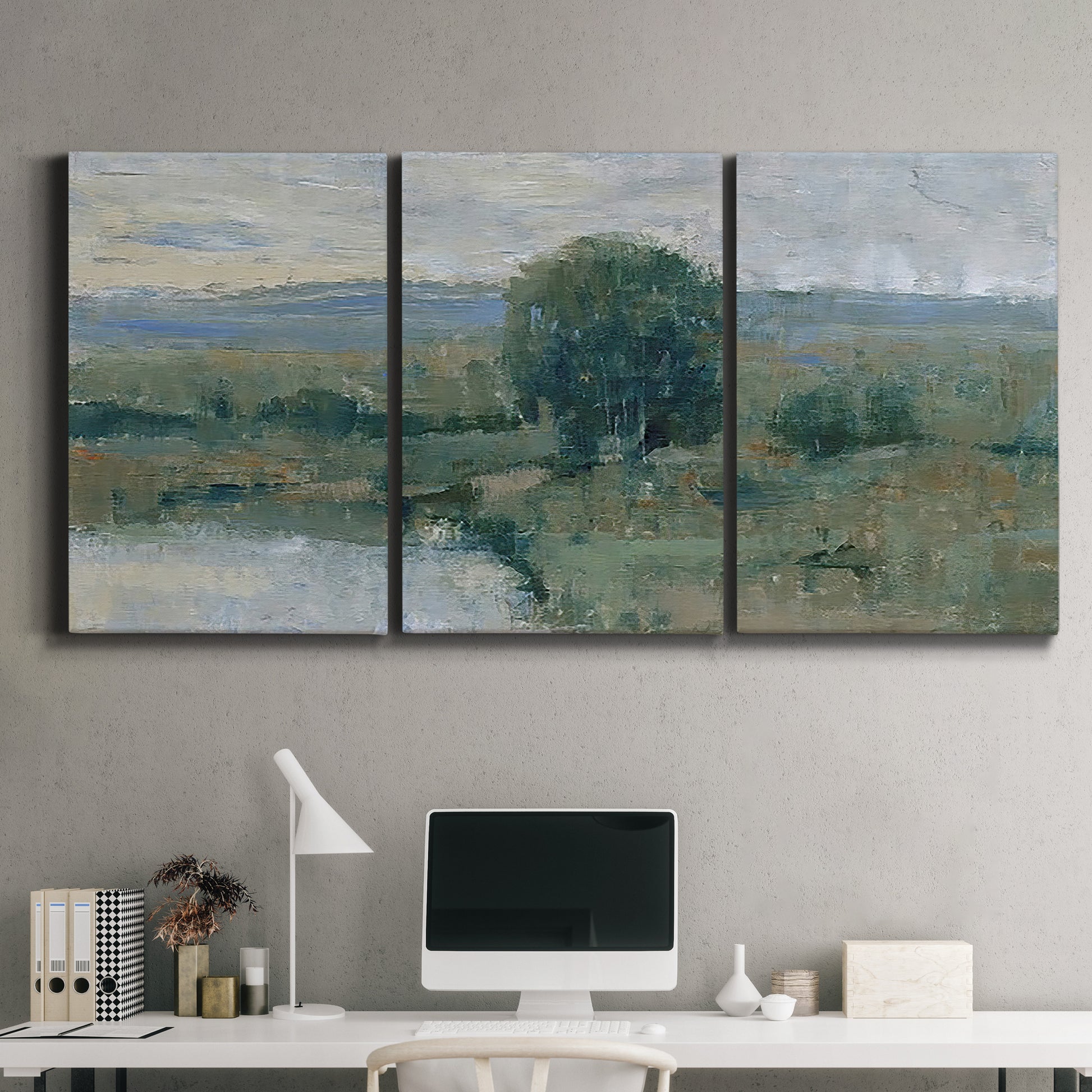 Three-panel canvas wall art featuring riverbank landscape with reflections, displayed above a desk in a home office.