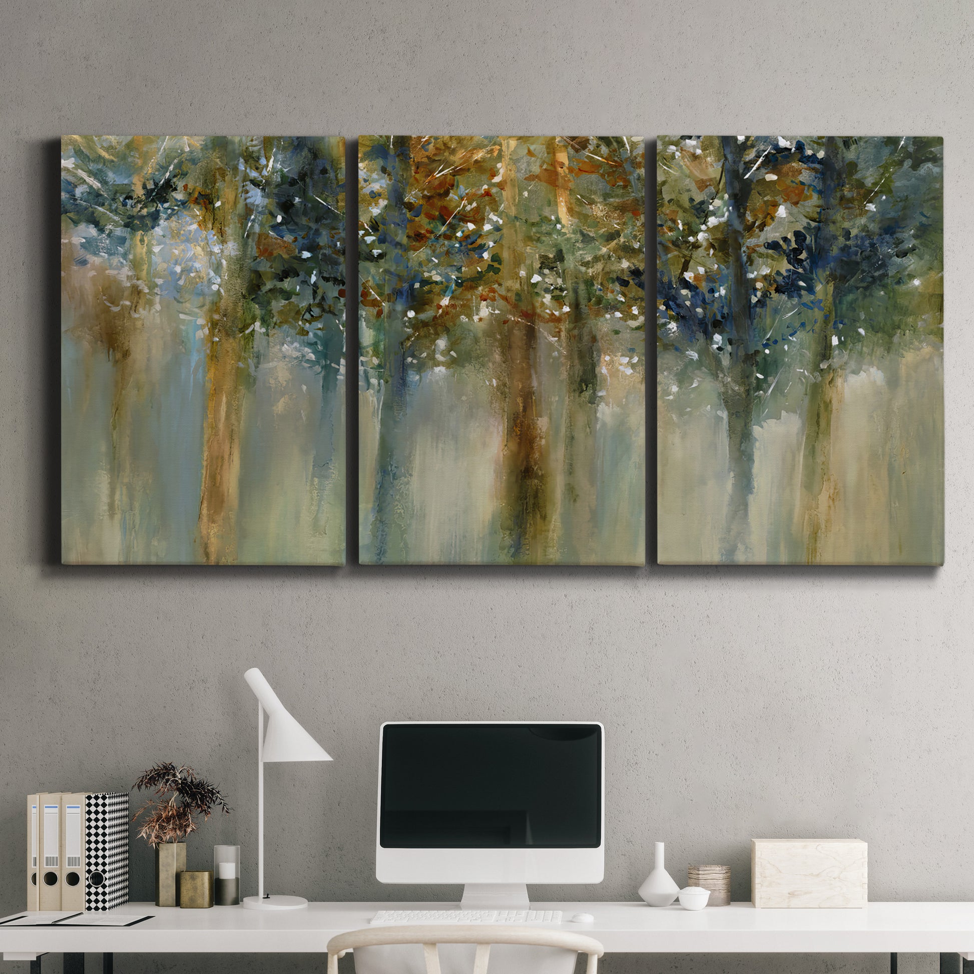 Three-panel canvas wall art featuring earth toned abstract leaf textures, displayed above a desk in a home office.