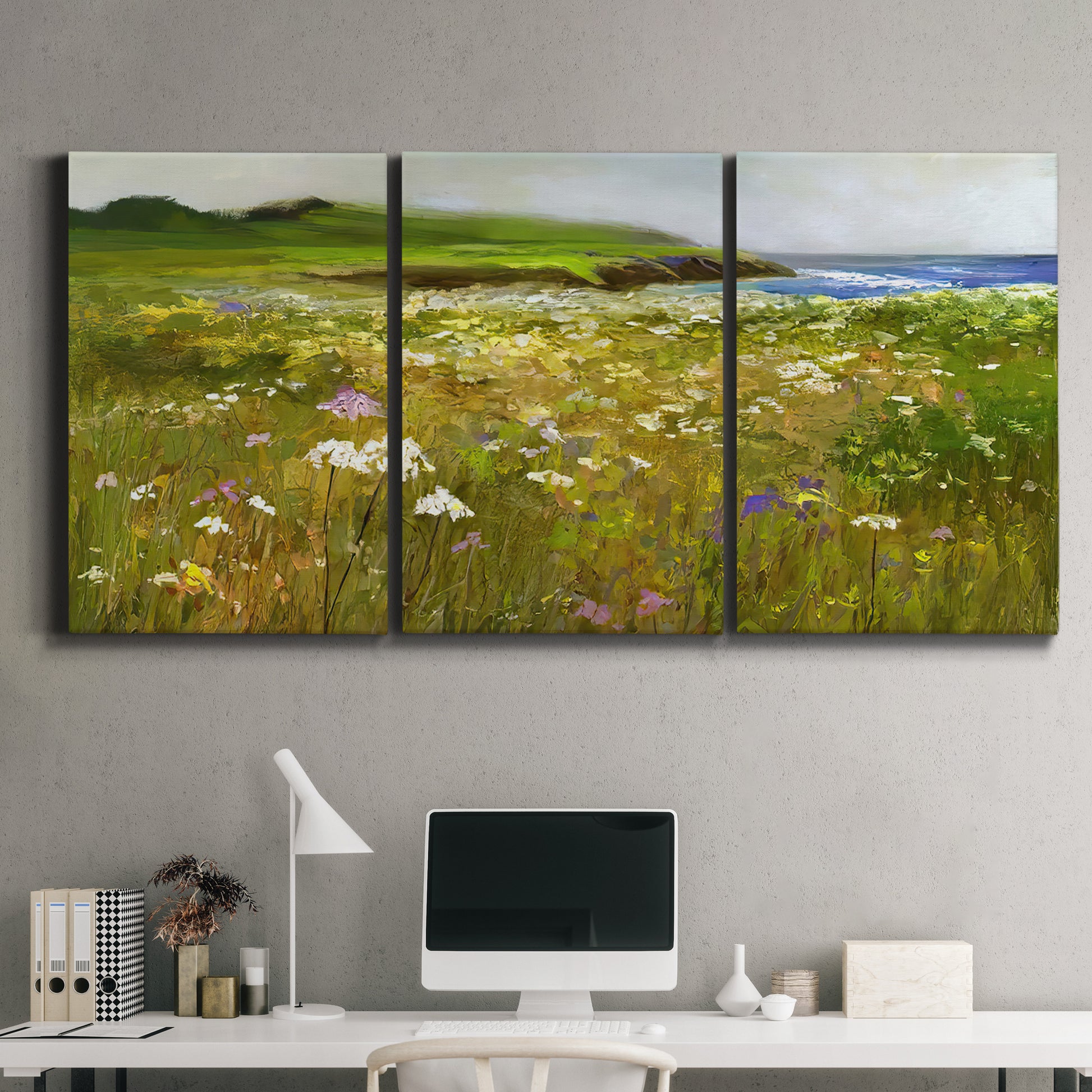 Three-panel canvas wall art featuring rugged coastal cliff landscape, displayed above a desk in a home office.