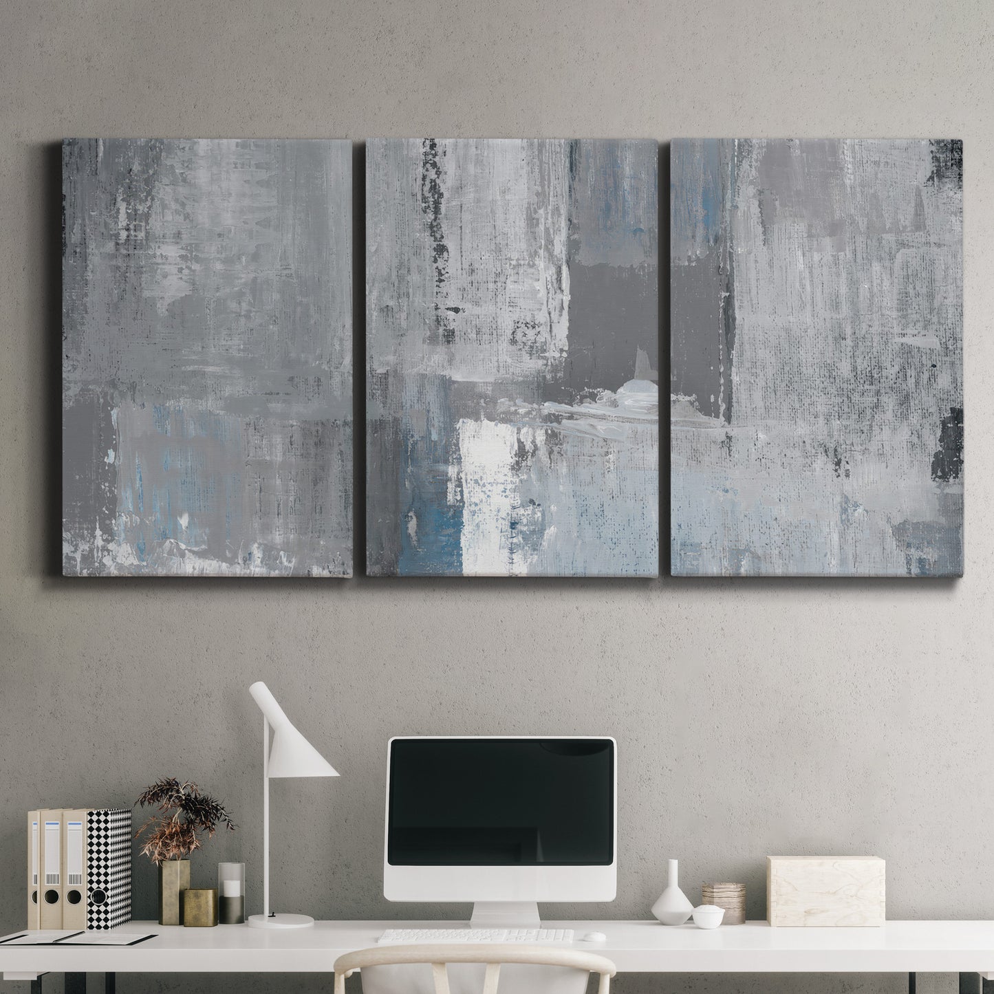 Three-panel canvas wall art featuring cool toned industrial abstract blues, displayed above a desk in a home office.