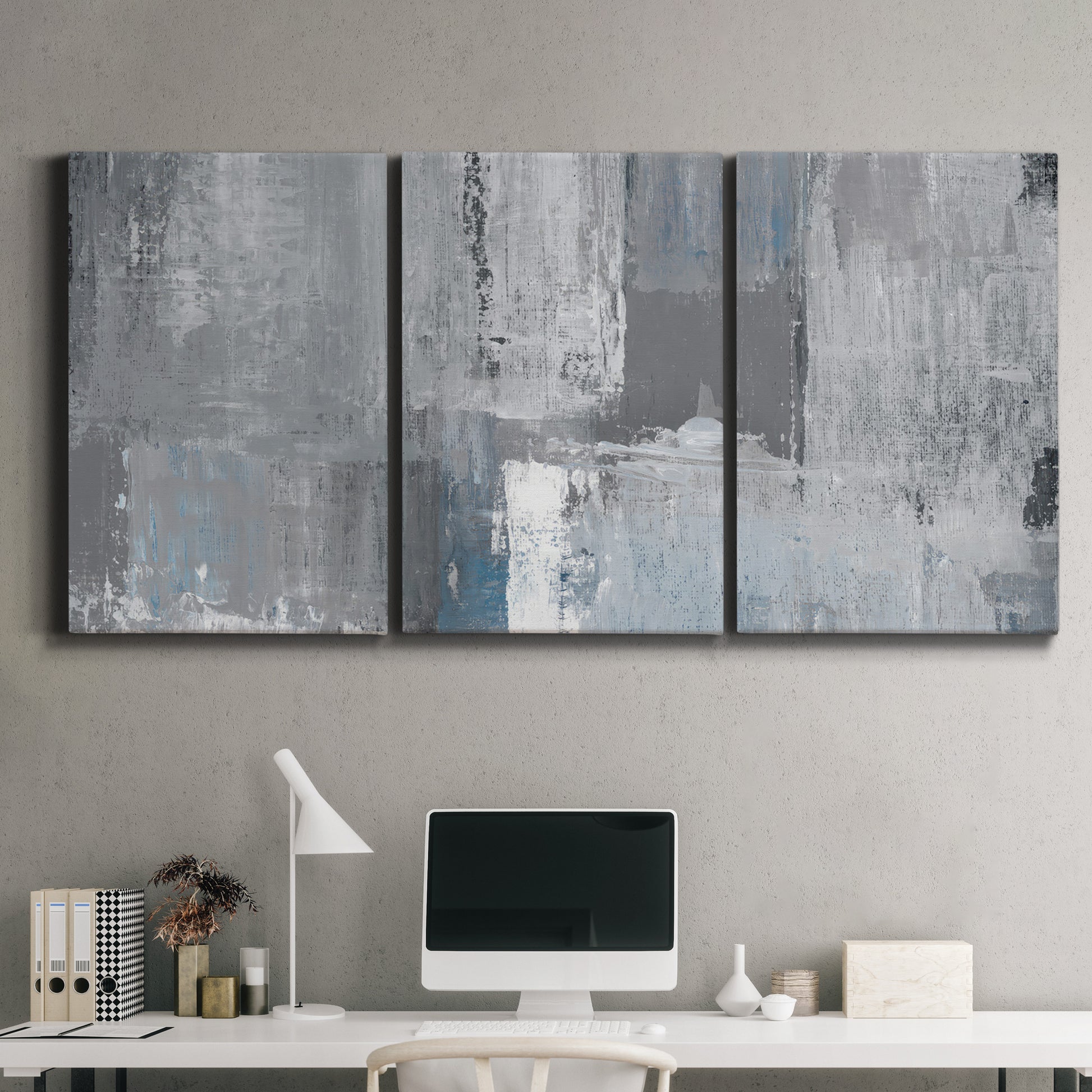 Three-panel canvas wall art featuring cool toned industrial abstract blues, displayed above a desk in a home office.