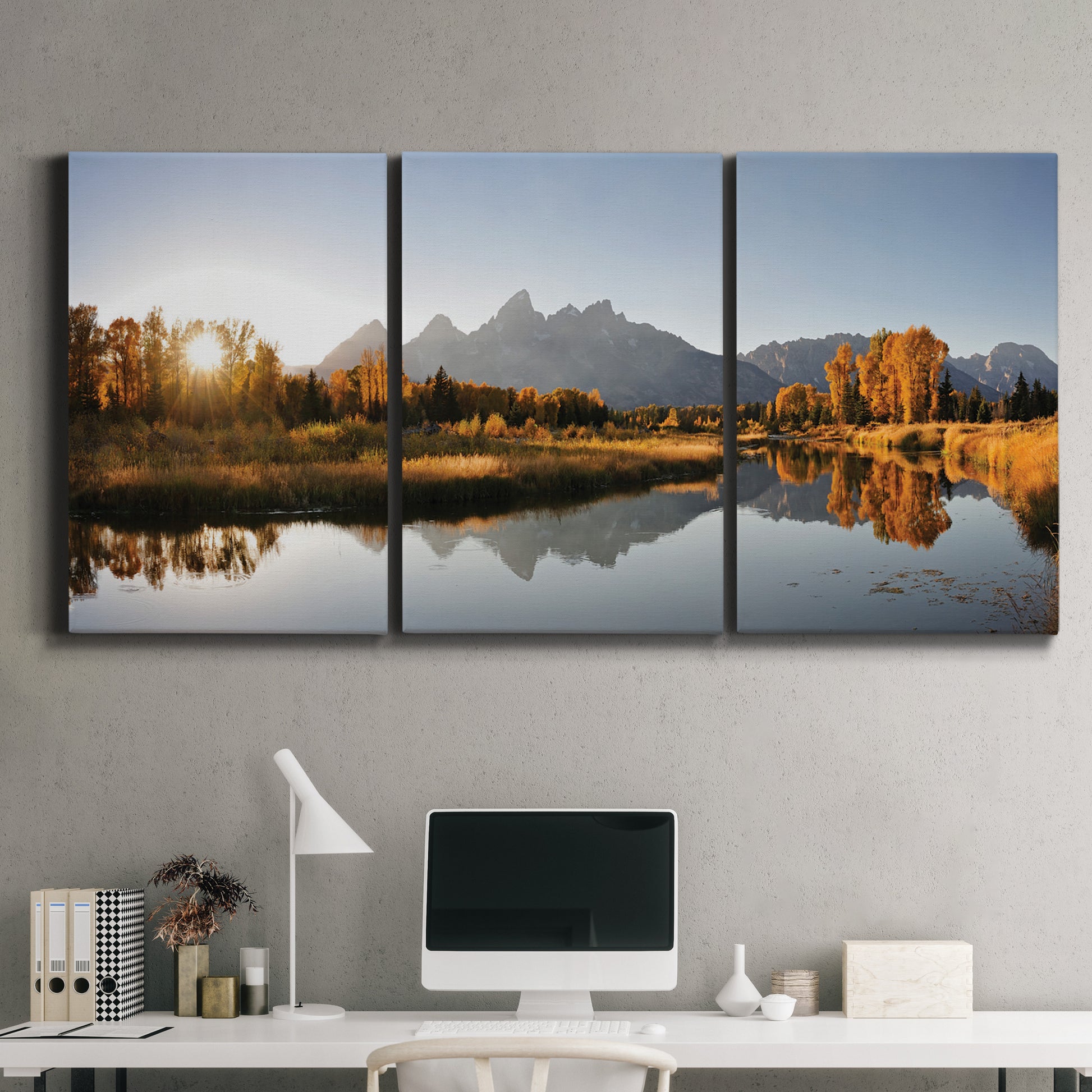 Three-panel canvas wall art featuring river canyon landscape photograph, displayed above a desk in a home office.