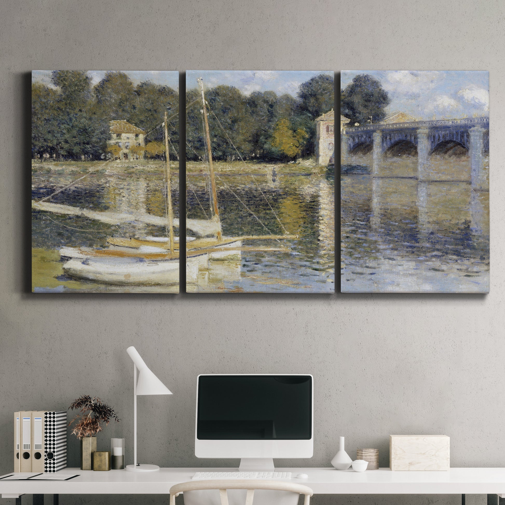 Three-panel canvas wall art featuring bridge crossing broad river, displayed above a desk in a home office.