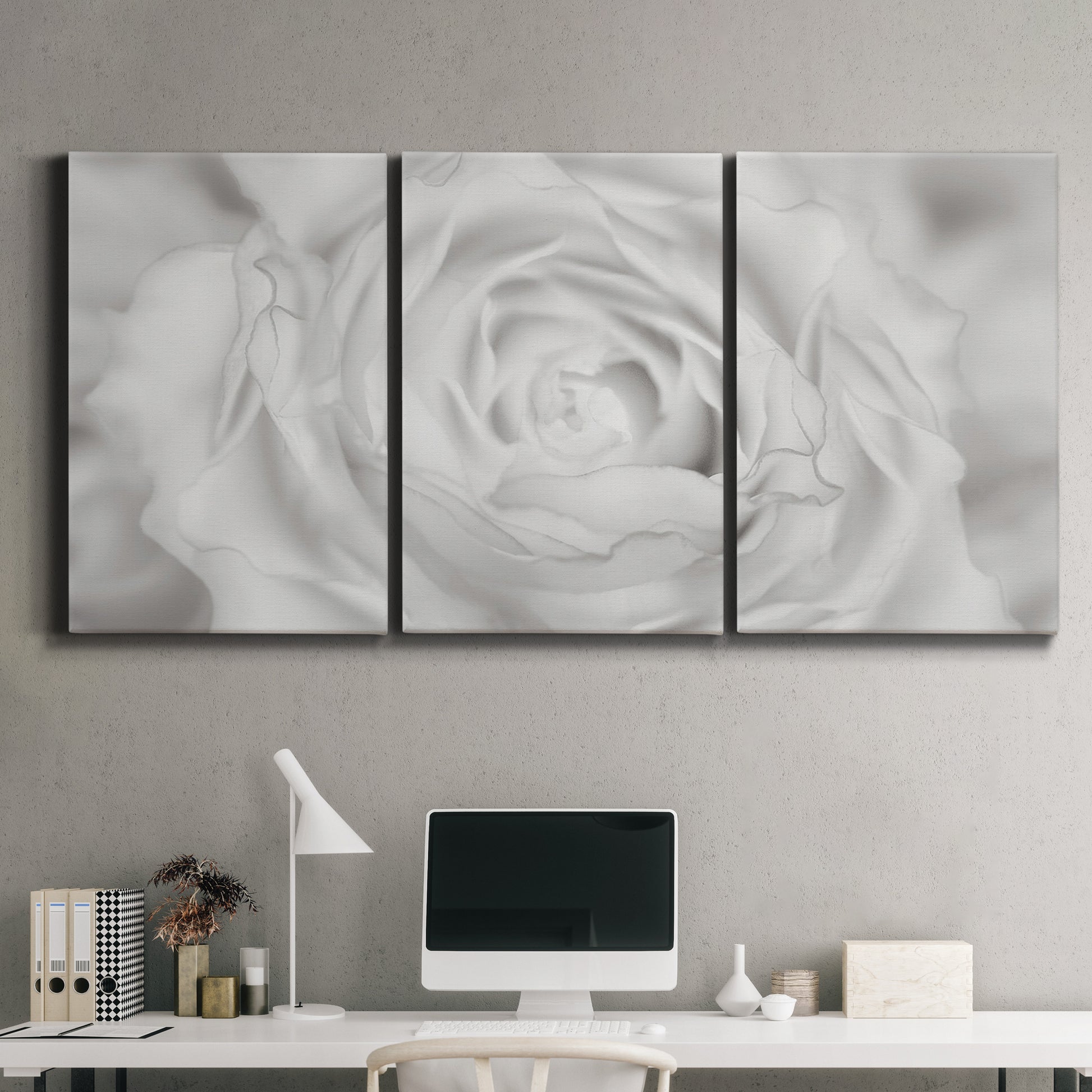 Three-panel canvas wall art featuring monochrome rose study photograph, displayed above a desk in a home office.