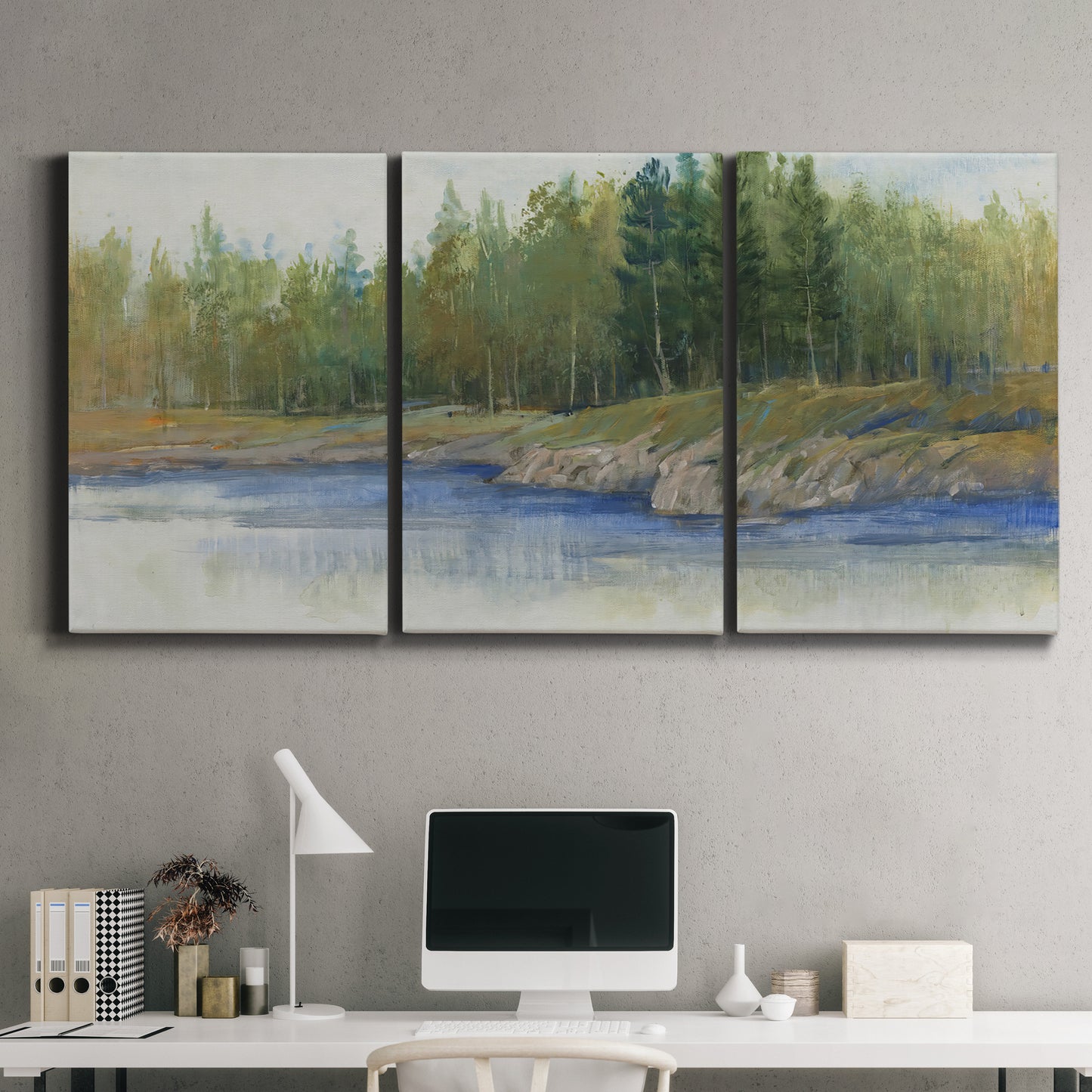 Three-panel canvas wall art featuring riverbank landscape with trees, displayed above a desk in a home office.