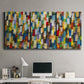 Three-panel canvas wall art featuring colorful confetti style abstraction, displayed above a desk in a home office.