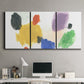 Three-panel canvas wall art featuring inkblot style abstract color symmetry, displayed above a desk in a home office.