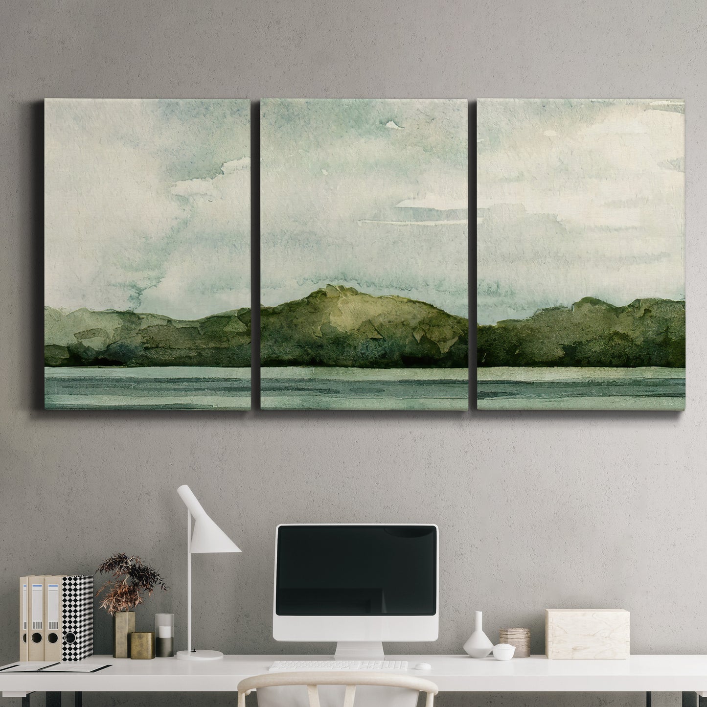 Three-panel canvas wall art featuring riverbank watercolor landscape, displayed above a desk in a home office.