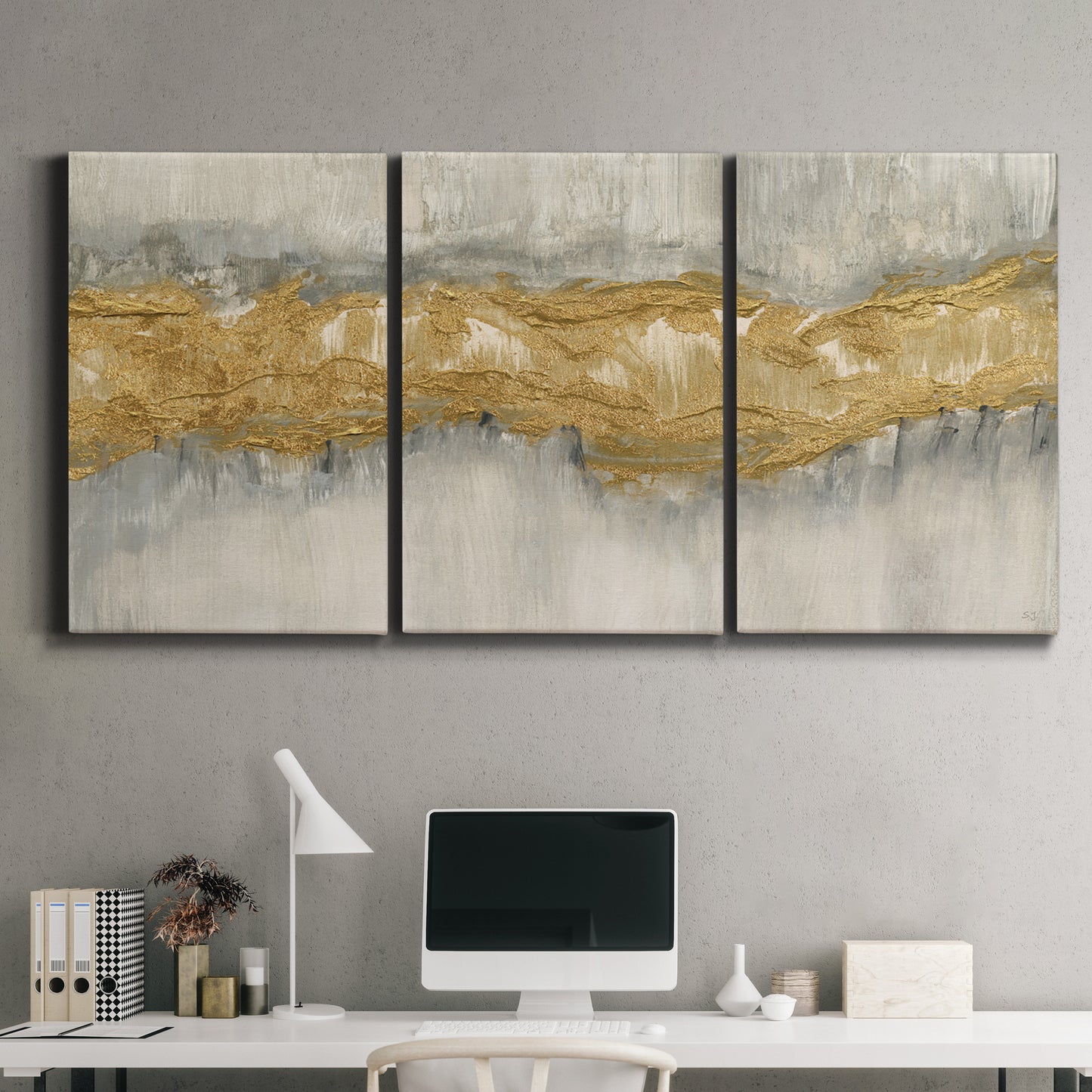Three-panel canvas wall art featuring flowing abstract golden tones, displayed above a desk in a home office.