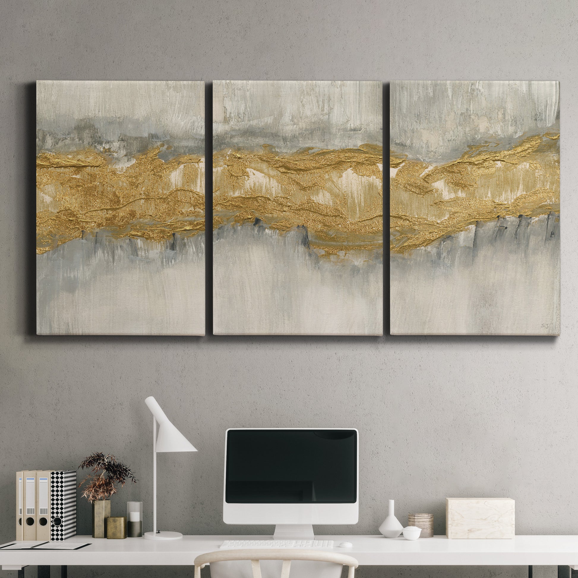 Three-panel canvas wall art featuring flowing abstract golden tones, displayed above a desk in a home office.